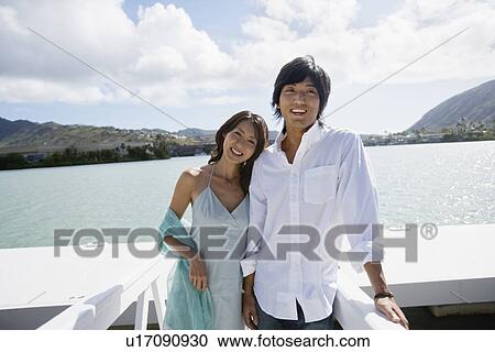 Stock Image - A young couple standing together. Fotosearch