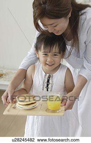 A girl holding a tray with some pancakes View Large Photo Image Stock Image - A girl holding a tray with some pancakes. Fotosearch
