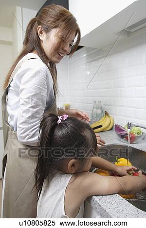 A mother and daughter in a kitchen View Large Photo Image Stock Photography - A mother and daughter in a kitchen. Fotosearch