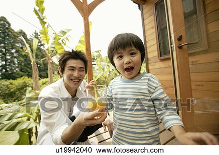 A small boy holding a straw as his father holds the glass of juice for him View Large Photo Image Stock Image - A small boy holding a straw as his father holds the glass of juice for him. Fotosearch