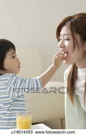 A son feeding mother View Large Photo Image Stock Image - A son feeding mother. Fotosearch
