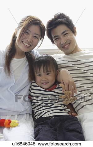 Stock Photograph - A young family sitting in a group. Fotosearch