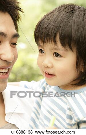 Close up of a young boy with his father View Large Photo Image Stock Photo - Close up of a young boy with his father. Fotosearch