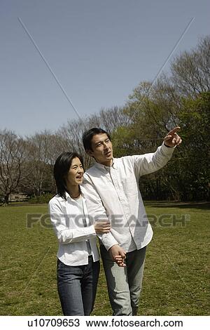 A young couple walking in garden View Large Photo Image Stock Image - A young couple walking in garden. Fotosearch