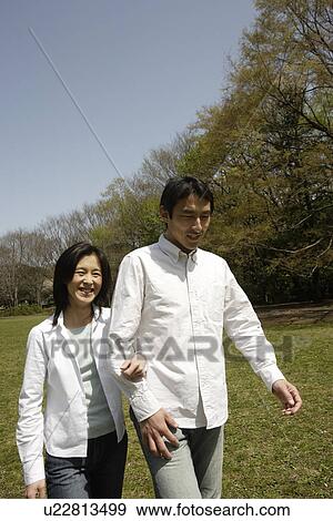 Stock Photo - A young couple walking in garden. Fotosearch