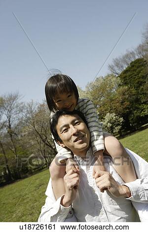 Stock Image - Portrait of a father carrying daughter. Fotosearch