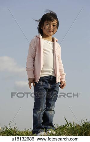 Portrait of a girl standing on grass View Large Photo Image Stock Photograph - Portrait of a girl standing on grass. Fotosearch