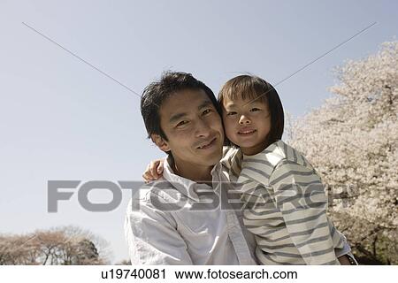 Stock Image - Portrait of father holding daughter. Fotosearch