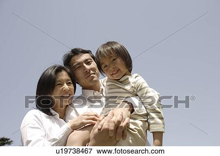 Stock Photo - Portrait of parents smiling with daughter. Fotosearch