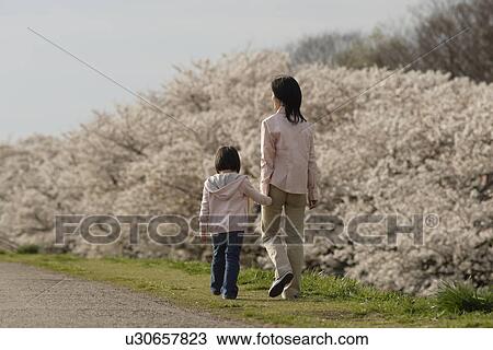 Rear view of a mother and daughter walking View Large Photo Image Stock Image - Rear view of a mother and daughter walking. Fotosearch