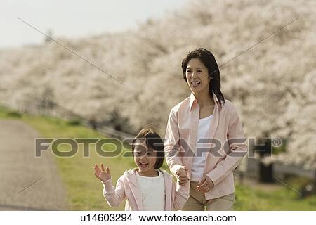 Picture - View of a mother and daughter holding hands. Fotosearch