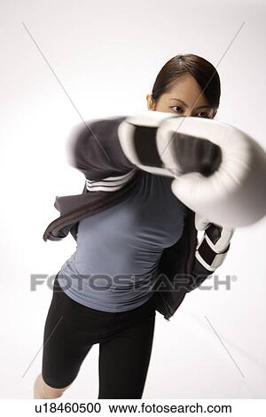 Stock Image - Portrait of a young woman boxing. Fotosearch