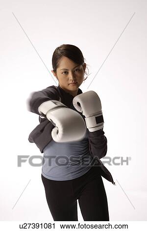 Stock Image - Portrait of a young woman boxing. Fotosearch