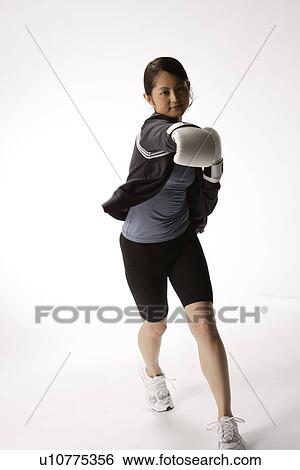 Stock Photograph - Portrait of a young woman boxing. Fotosearch