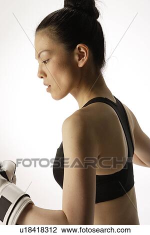 Stock Image - Portrait of a young woman with boxing gloves. Fotosearch