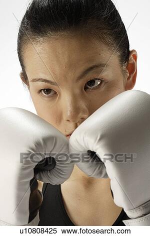 Stock Photography - Portrait of a young woman with boxing gloves. Fotosearch