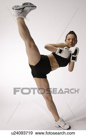View a young woman kicking View Large Photo Image Stock Photo - View a young woman kicking. Fotosearch