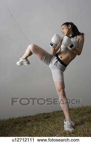 View of a young woman kicking View Large Photo Image Stock Image - View of a young woman kicking. Fotosearch