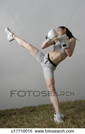 Stock Photography - View of a young woman kicking. Fotosearch