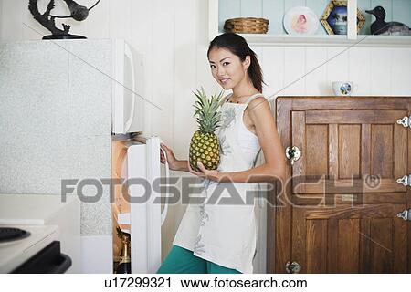 A young woman holding pineapple View Large Photo Image Stock Image - A young woman holding pineapple. Fotosearch