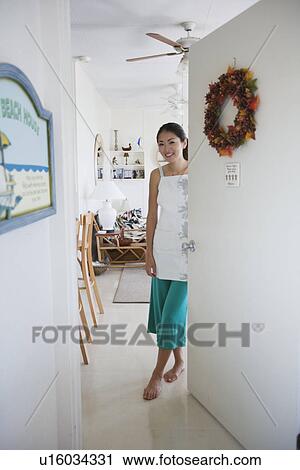 A young woman standing by door View Large Photo Image Stock Image - A young woman standing by door. Fotosearch