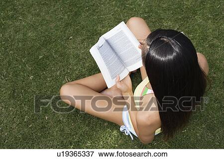 Elevated view of a woman reading book View Large Photo Image Stock Photo - Elevated view of a woman reading book. Fotosearch