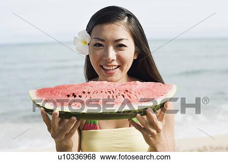 Stock Photo - Portrait of a young woman holding watermelon. Fotosearch