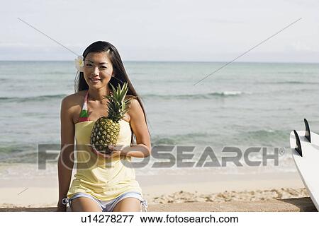 Portrait of a young woman holding pineapple View Large Photo Image Stock Photo - Portrait of a young woman holding pineapple. Fotosearch