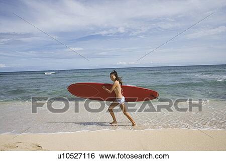 Portrait of a young woman running on beach View Large Photo Image Stock Photograph - Portrait of a young woman running on beach. Fotosearch