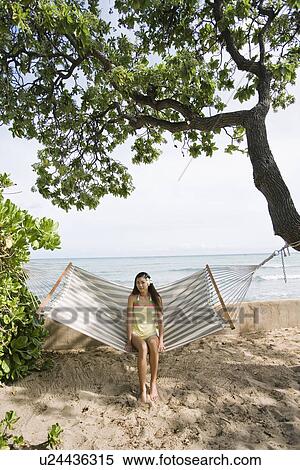 Stock Photography - Portrait of a young woman sitting on a hammock. Fotosearch
