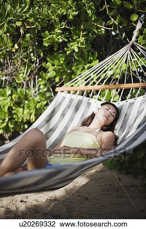 View of a young woman lying on a hammock View Large Photo Image Stock Image - View of a young woman lying on a hammock. Fotosearch