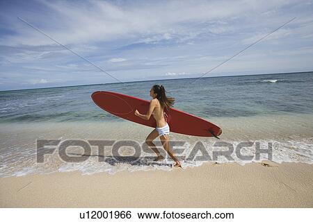 View of a young woman running on beach View Large Photo Image Stock Photograph - View of a young woman running on beach. Fotosearch