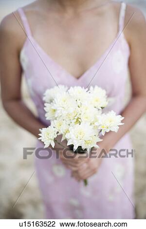 A woman holding bouquet of flowers View Large Photo Image Stock Image - A woman holding bouquet of flowers. Fotosearch