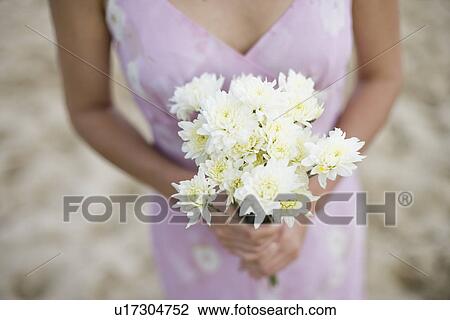 Stock Image - A woman holding bouquet of flowers. Fotosearch