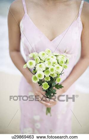 A woman holding bouquet of flowers View Large Photo Image Stock Image - A woman holding bouquet of flowers. Fotosearch