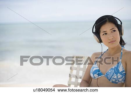 A woman listening music at beach View Large Photo Image Picture - A woman listening music at beach. Fotosearch