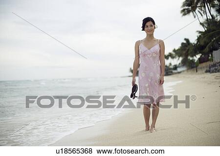 A young woman standing on beach View Large Photo Image Stock Photo - A young woman standing on beach. Fotosearch