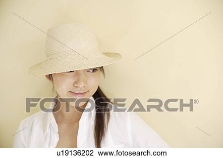 Stock Image - A young woman wearing hat. Fotosearch