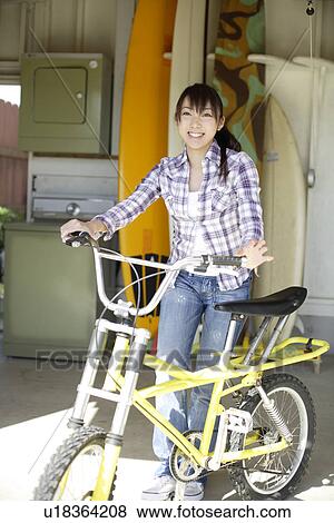 View of a smiling woman with bicycle View Large Photo Image Stock Photo - View of a smiling woman with bicycle. Fotosearch