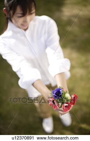 View of a woman holding flowers View Large Photo Image Stock Image - View of a woman holding flowers. Fotosearch