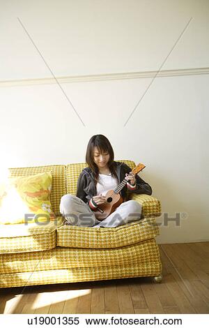 View of a young woman playing guitar View Large Photo Image Stock Photography - View of a young woman playing guitar. Fotosearch