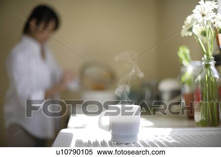 Woman with cup of coffee in foreground View Large Photo Image Stock Photography - Woman with cup of coffee in foreground. Fotosearch