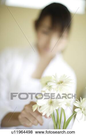 Woman with flowers in foreground View Large Photo Image Stock Photo - Woman with flowers in foreground. Fotosearch