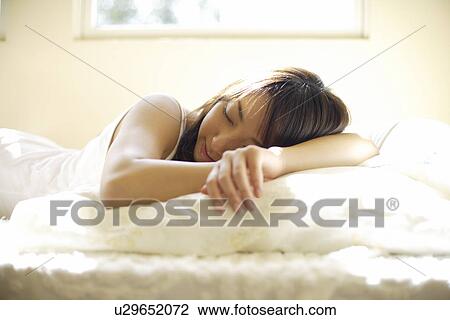 Young woman sleeping on bed View Large Photo Image Stock Image - Young woman sleeping on bed. Fotosearch