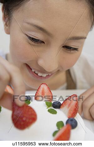 Close-up of a young woman garnishing a pastry View Large Photo Image Stock Image - Close-up of a young woman garnishing a pastry. Fotosearch