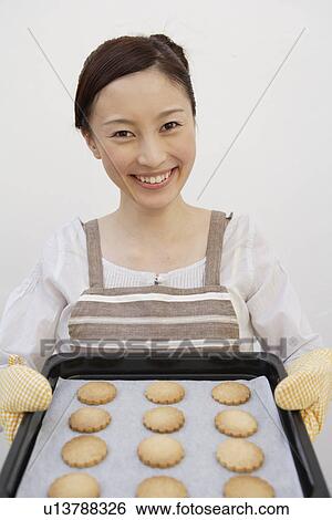 Portrait of a woman holding tray of biscuits View Large Photo Image Stock Photograph - Portrait of a woman holding tray of biscuits. Fotosearch