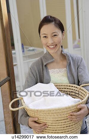 Stock Photo - Portrait of a young woman holding a basket. Fotosearch