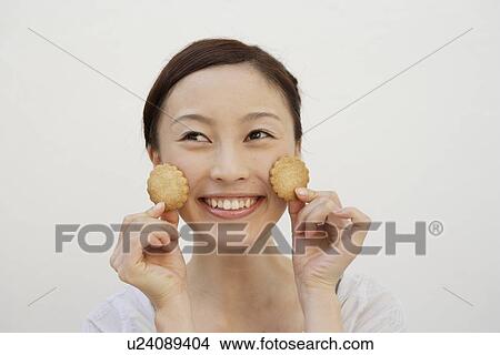 View of a cheerful woman holding biscuits View Large Photo Image Picture - View of a cheerful woman holding biscuits. Fotosearch