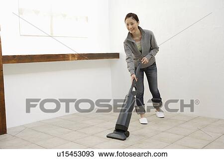 View of a young woman cleaning a room View Large Photo Image Stock Image - View of a young woman cleaning a room. Fotosearch