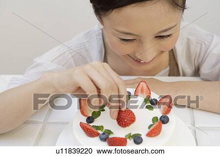 View of a young woman garnishing a pastry View Large Photo Image Stock Image - View of a young woman garnishing a pastry. Fotosearch